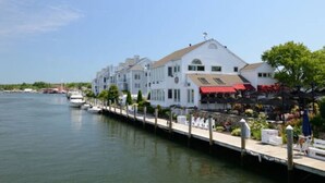Ein Hotel am Wasser mit Anlegesteg, einer Reihe weißer Gebäude und einem Boot im Wasser.