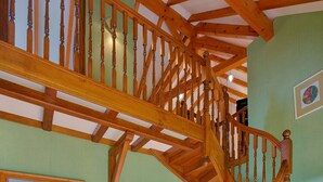 A wooden staircase with a curved design leading to an upper floor. - At Au Pif: family, hiking, spa bath & nature (Volmunster)