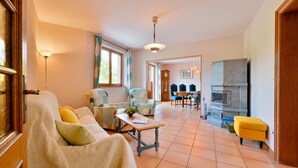 A cozy living room with a sofa, armchairs, a dining table, and a fireplace. - At Au Pif: family, hiking, spa bath & nature (Volmunster)