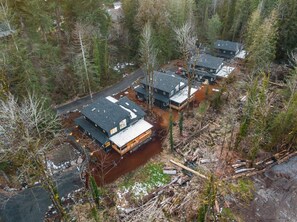 Un ensemble de chalets situés dans une zone boisée, accessibles par un chemin de terre.