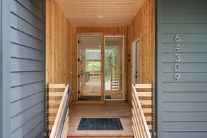 A wooden exterior entrance with a set of double doors, a small porch area, and a number '64309' on the wall. - Sandy River Group Getaway 3 (Mount Hood Village)