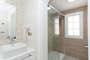 Villa | Badkamer | Een douche, een haardroger, handdoeken