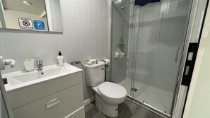 A modern bathroom with a toilet, sink, and shower. There are signs on the wall indicating no drinking and no wasting water. - Modern Tiny Country House Near Fataga & Maspalomas (San Bartolomé de Tirajana)