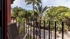 A balcony with a view of a street, palm trees, and a crosswalk. - Luxury 2-bed Apartment Elviria - Pool, Sauna & gym (Marbella)