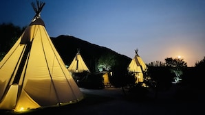 Several illuminated teepees in a campsite setting at night. - Beautiful Teepee With Private Facilities (Zujar)