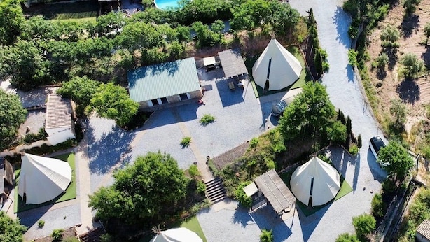 An aerial view of a campsite with multiple tents, a swimming pool, and a paved parking area. - Beautiful Teepee With Private Facilities (Zujar)