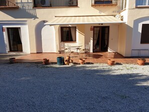 A building with a covered patio area, outdoor seating, and potted plants. - Delightful Spacious 2 bed Apartment in Nerja (Nerja)