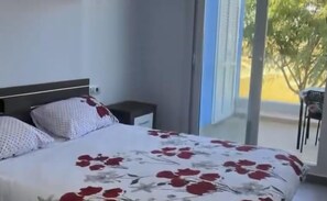 A bedroom with a bed, a nightstand, and a chair. - Stylish 2-bed Apartment Overlooking the Fairways (Torre-Pacheco)