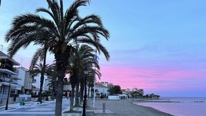 A beachside promenade with palm trees, a paved walkway, and buildings in the background. - Stylish 2-bed Apartment Overlooking the Fairways (Torre-Pacheco)