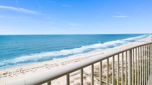 A beach view from a balcony with a railing, ocean, and a pier in the distance. - TURQUOISE Place.  3 bed 3 bath.  Sleeps 12. Balcony Hot Tub.  August 25% off. (Orange Beach)