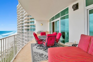 A balcony with a table and chairs, a sofa, and a view of the ocean. - Welcome to Turquoise C1408 in Orange Beach, Alabama. (Orange Beach)