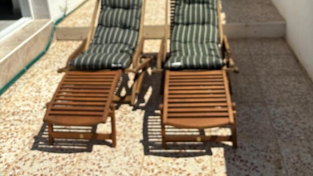 A patio with a table and chairs, two lounge chairs, and a small table with a chair. - Casa Amira a Modern House With Pool (Pulpi)