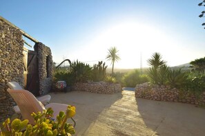 A patio area with stone walls, a wooden door, and a view of the landscape. - Fantastic View and Lovely Atmosphere Casita Adelfa (Alhaurin de la Torre)
