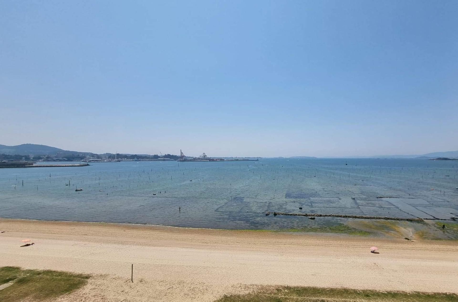 A coastal view with a sandy beach and calm sea.