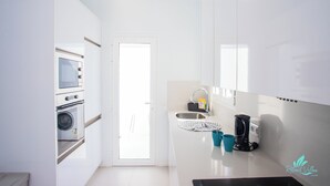 Eine moderne Küche mit integrierten Geräten, einer Spüle und einer Kaffeemaschine.