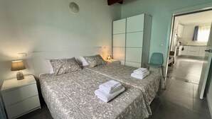 A neatly made bed with a patterned bedspread and pillows, a bedside lamp, and a folded towel on the nightstand. - Large Country House Near Maspalomas & Fataga (San Bartolomé de Tirajana)