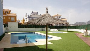 A swimming pool with a thatched roof structure, surrounded by artificial grass and a circular water feature. - 2 Bed House - Sleeps 4 - Pool - Terrace - Parking (Pulpi)