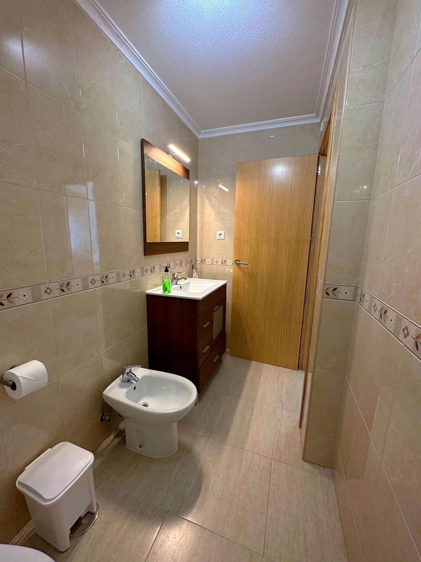 Une salle de bain équipée de toilettes, d’un bidet, d’un lavabo et d’un miroir.