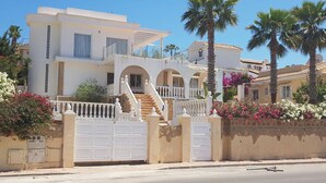 A multi-story house with a white facade, a gated entrance, and a staircase leading to the upper floor. - 3-bed Villa Sleeps 8 With Private Pool (Santa Pola)