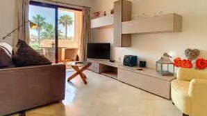Una sala de estar moderna con un sofá, un televisor y elementos decorativos.