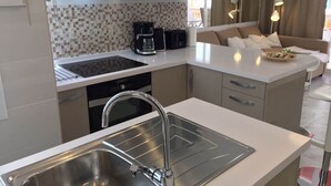 A modern kitchen with a stainless steel sink, a coffee maker, and a microwave. - Apartment Sleeps 4 Near Beach (Fuengirola)