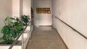 A staircase with a handrail, potted plants, and a wall-mounted cabinet with drawers. - Central Attic Apt Sleeps 4 With Patio (Almunecar)