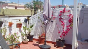 A rooftop garden with potted plants and a pergola. - Central Attic Apt Sleeps 4 With Patio (Almunecar)