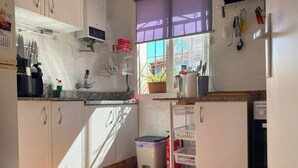 A kitchen with white cabinets, a granite countertop, a built-in oven, and a window with a purple blind. - Central Attic Apt Sleeps 4 With Patio (Almunecar)