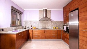 A kitchen with wooden cabinets, a stainless steel refrigerator, and a granite countertop. - Costa Blanca, Private Pool, Full Aircon, Sleeps 12 (Benimeli)