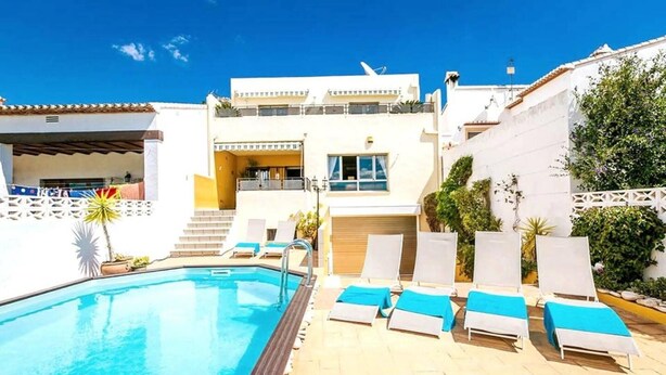 A swimming pool with lounge chairs and a building with a balcony. - Costa Blanca, Private Pool, Full Aircon, Sleeps 12 (Benimeli)