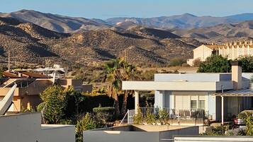 Zona residencial con casas modernas, vistas despejadas de montañas distantes y algunas palmeras.