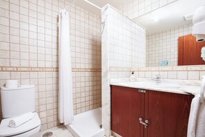 A bathroom with a toilet, shower, and wooden vanity with a mirror. - Casa Naranja Sleeps 6 With Golf Views (La Oliva)