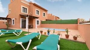Ein Gebäude mit Pool, Außenbereich und Pflanzen in Töpfen.
