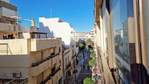 A narrow street with buildings on both sides, featuring balconies and a clear blue sky. - 3 Bed Apartment Sleeps 6 - Free Parking & Balcony (Estepona)