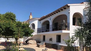 A two-story house with a patio area, outdoor seating, and a small garden. - Lovely 2 Bed Apartment in Alcalali (Alcalali)