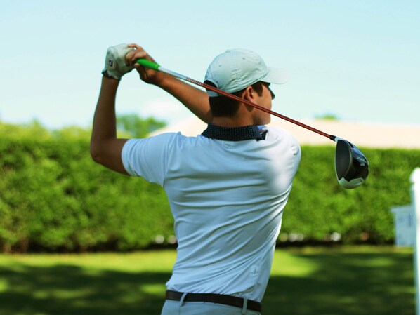 A golfer in a white shirt and cap, swinging a golf club. - Stunning Apartment Close to Golf, Mijas, Spain (Mijas)