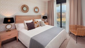 A hotel room with a large bed, two bedside tables with lamps, a chair, and a view of the outdoors. - Stunning Apartment Close to Golf, Mijas, Spain (Mijas)