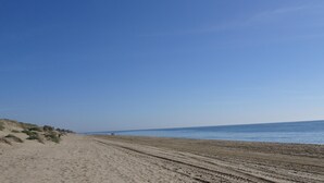 A beach with a clear sky and a sandy path leading to the water. - Elviria 2-bed Apt, Sleeps 4, Pool, 20m to Beach (Marbella)