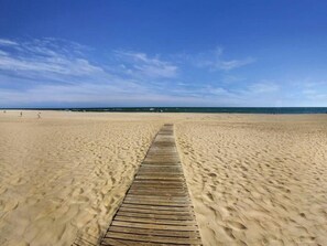 A wooden boardwalk leading to a sandy beach with a clear blue sky. - Charming 2-bed Apartment Near Ayamonte With Pool (Ayamonte)