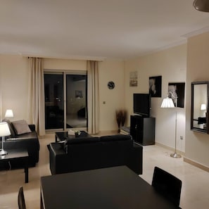 Una sala moderna con un sofá, una mesa de comedor y un televisor.