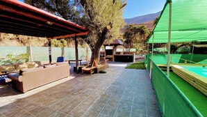 Eine Außenpatio mit Pool, Sitzbereich und überdachtem Bereich.