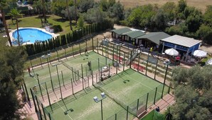 A sports complex with multiple tennis courts, a swimming pool, and a covered seating area. - Casa Buganvilla 11 at Lauro Golf (Alhaurin de la Torre)