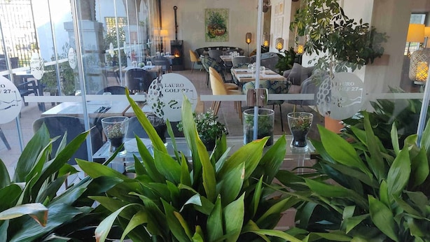 A restaurant with tables and chairs, potted plants, and a sign reading "LAURO GOLF 27". - Casa Buganvilla 11 at Lauro Golf (Alhaurin de la Torre)