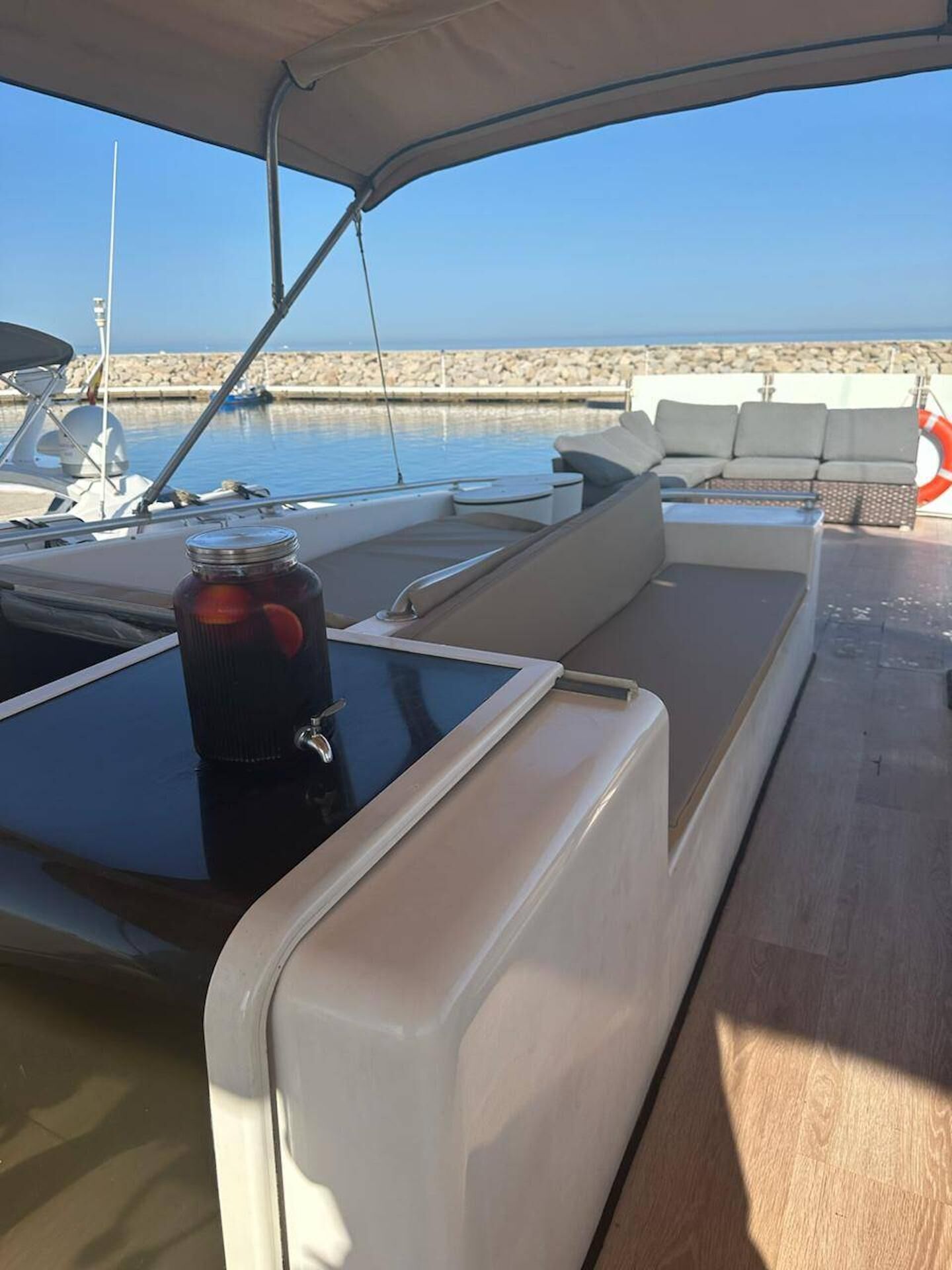 Ein Boot mit einer gepolsterten Sitzgelegenheit und einem Tisch mit einem Glas.