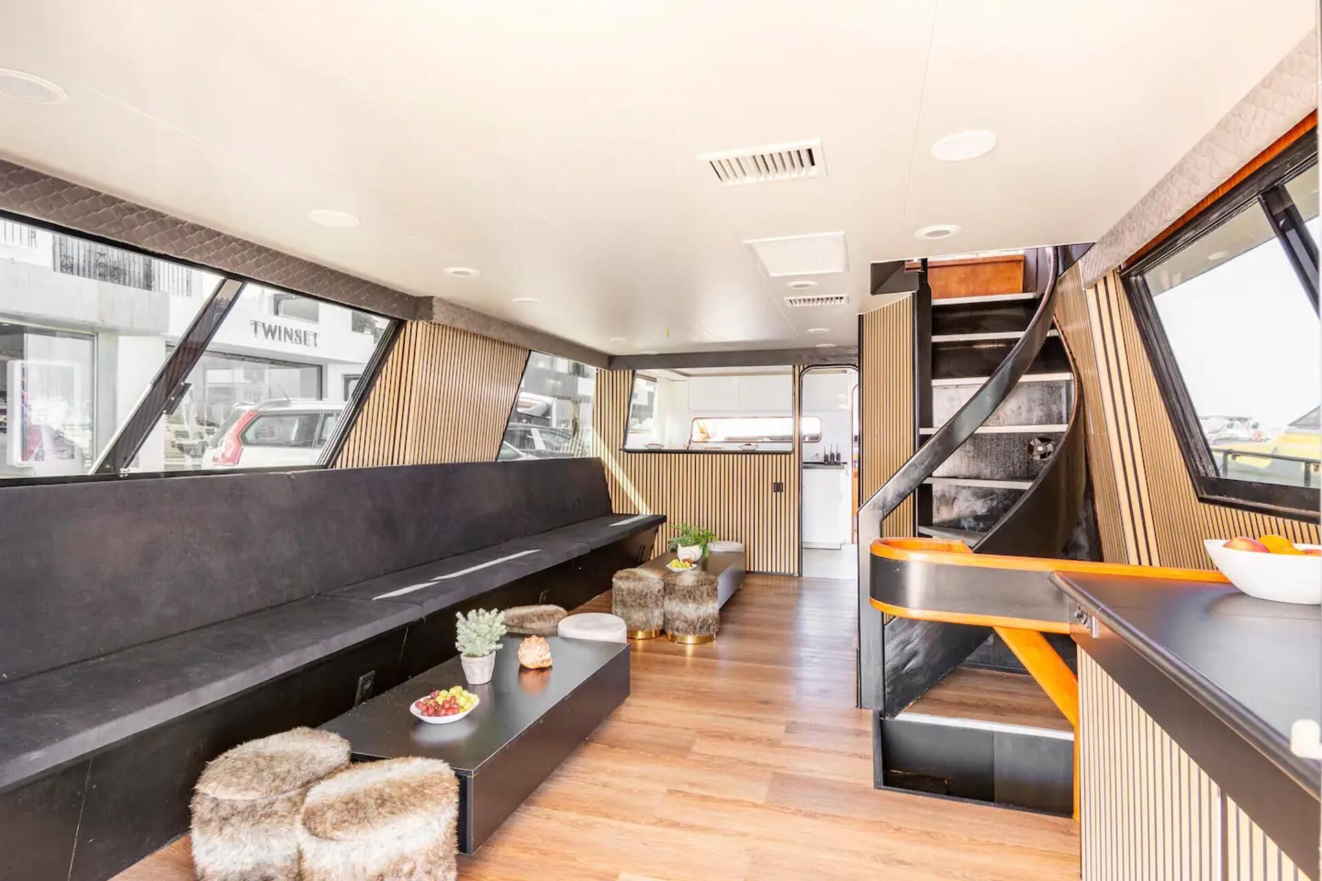 Un interior moderno con una zona de estar, una cocina y una escalera.