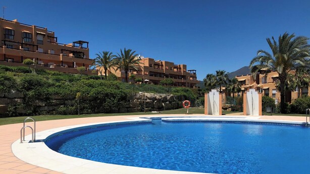 Une piscine à l’eau d’un bleu limpide, entourée d’une terrasse carrelée.