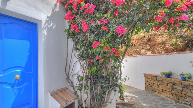 A blue door, a stone wall, and a potted plant. - Casa Redonda a Tranquil Spacious Apartment (Còmpeta)