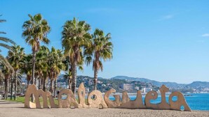 A beach with palm trees and a large sand sculpture. - Malaga Cityheart Stay Bright Modern City (Málaga)