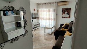 A living room with a TV, a sofa, a coffee table, and a TV stand. - Minerva 1-bedroom, Close to the Beach, Park etc (Benalmádena)