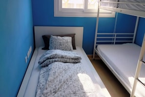 A bunk bed room with blue walls, a white headboard, and a window above the bed. - Lovely 2-bed Apartment in Condado de Alhama (Fortuna)